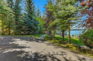 Une allée pavée mène à une maison qui offre une vue sur un lac.