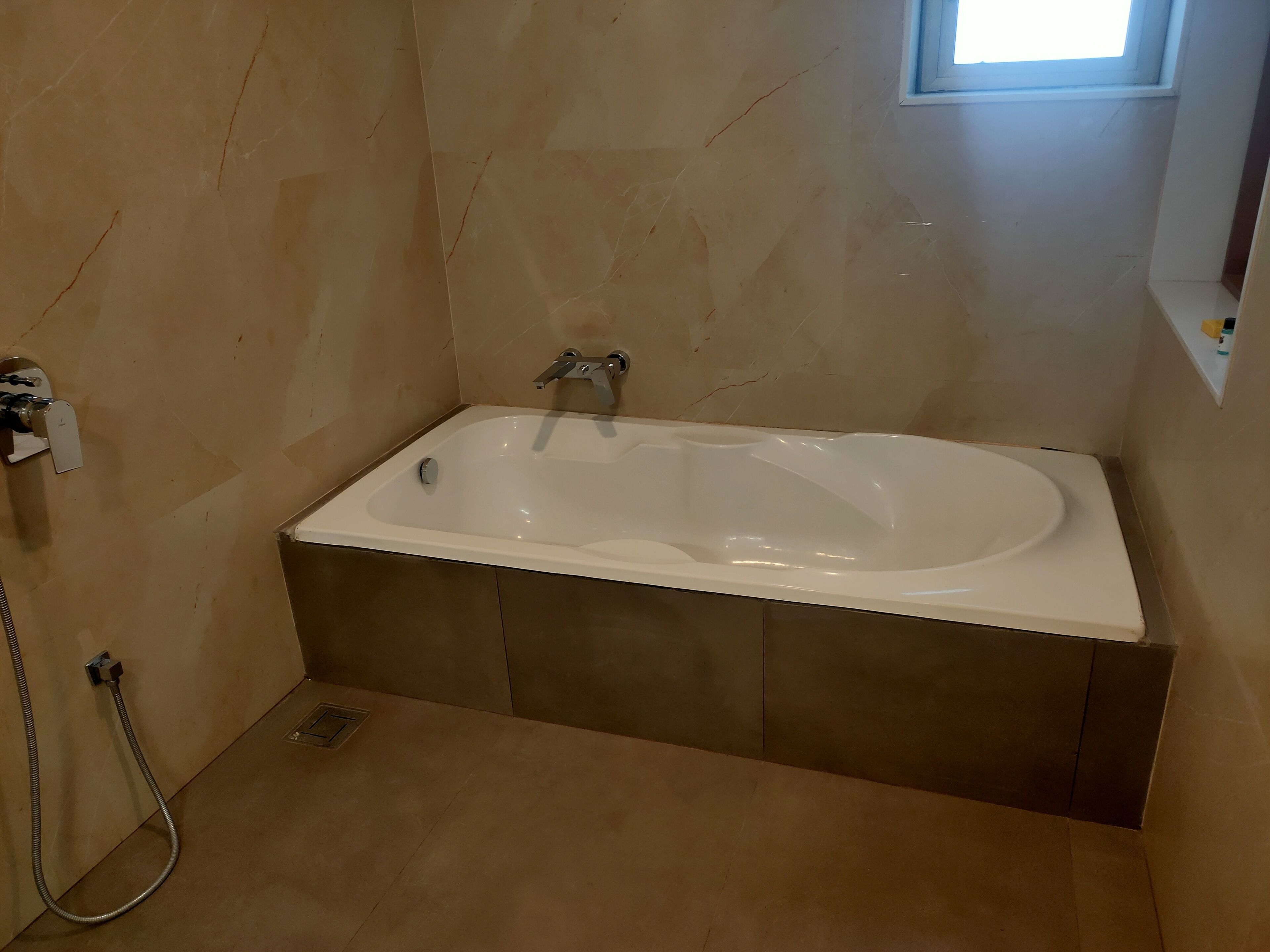 Une salle de bain avec une baignoire sur pieds, une douche et une fenêtre.
