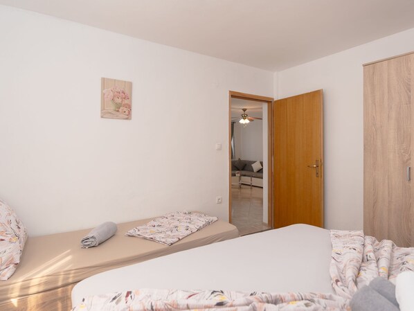 A bedroom with a bed, a bedside table, a wardrobe, and a small wall decoration. - Apartment Mia by Interhome (Novigrad (Zadar))