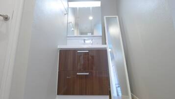 A narrow hallway with a wooden cabinet and a white door.