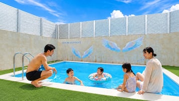 A swimming pool with a mural of wings and the text 'Kourijima Ocean Palace' on the wall.