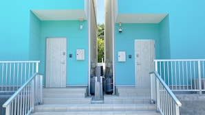 A set of stairs leading to a building with two doors, each marked with a letter.