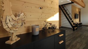 Un intérieur moderne avec un mur en bois, un escalier, un meuble noir et un vélo.