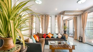 Un saló modern amb un sofà, una taula de centre i una planta gran en test.