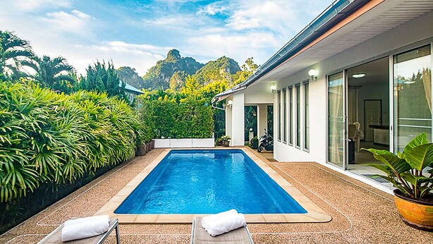 Una zona de piscina moderna amb una vista despejada d'una serralada al fons.
