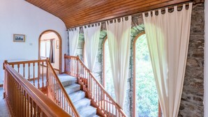 A staircase with wooden railings and a stone wall.