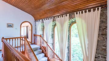 A staircase with wooden railings and a stone wall.