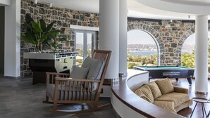 A spacious living area with a pool table, a comfortable seating area, and a view of the outdoors. - Pristine Seaview Villa , with 5-Star Resort Access (Faliraki)
