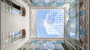 A view of a room with a skylight, large windows, and a patterned ceiling. - Numa Seville Solea (Seville)