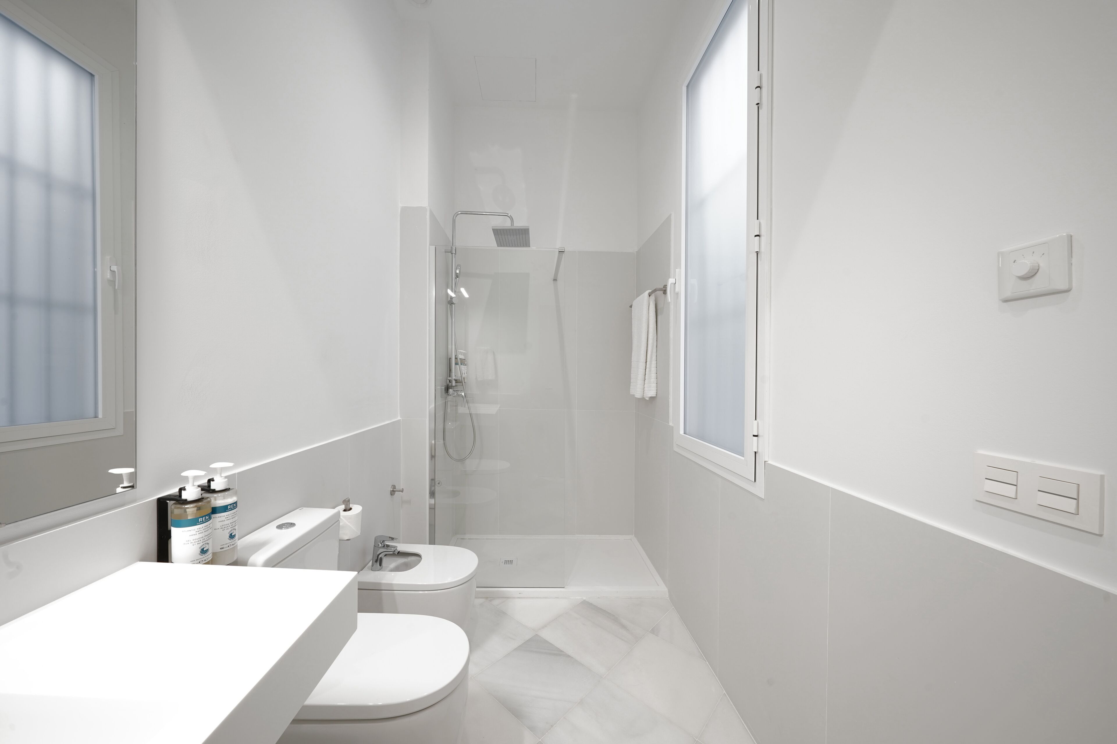 A modern bathroom with a toilet, sink, and shower.