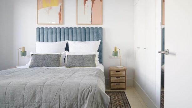 A neatly arranged bedroom with a bed, bedside tables, and artwork on the walls. - Numa Seville Solea (Seville)