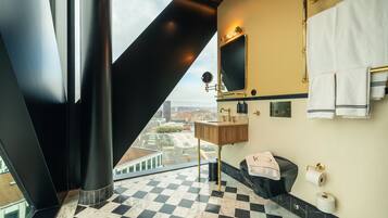 A modern bathroom with a checkered floor, a large mirror, a sink, and a toilet.