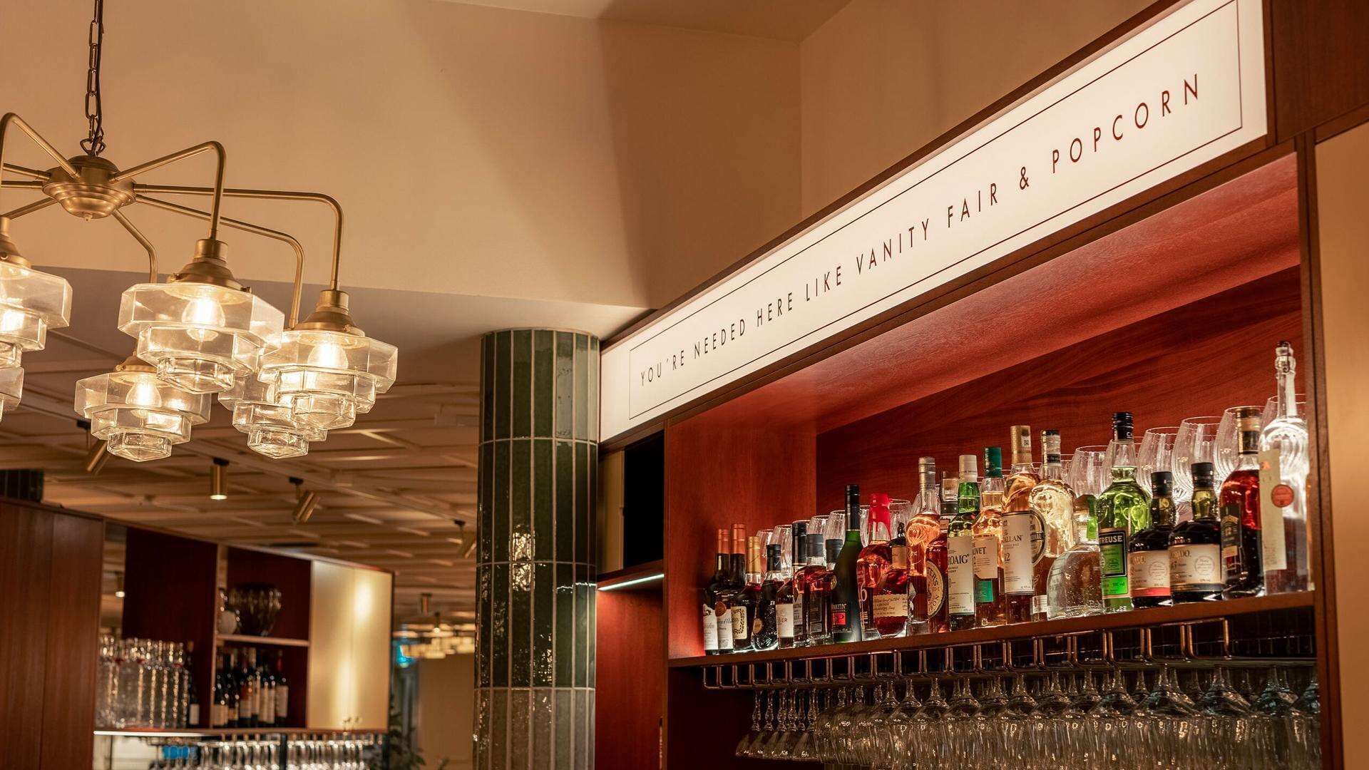 Zona de bar con un letrero que anuncia una fiesta de Vanity Fair y palomitas.