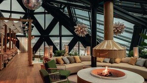 A modern interior with a large window, a fireplace, and a seating area with a sofa and chairs. - Jacy'z Hotel & Resort (Gothenburg)