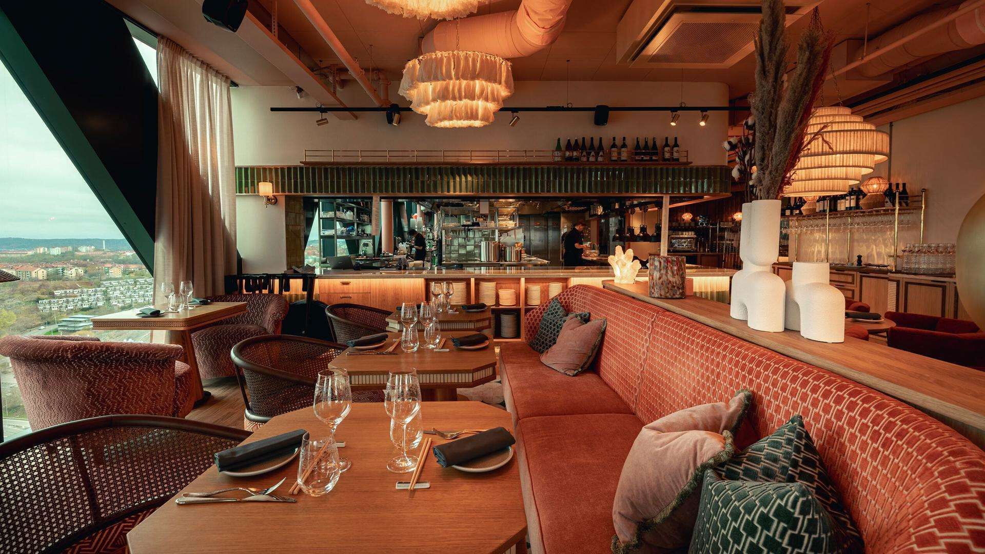 Un restaurant doté d’un bar, de tables et offrant une vue sur la ville.
