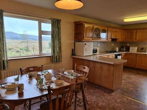 A kitchen with wooden cabinets, a central island, and a dining table set for four.