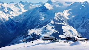 A snow-covered mountain with a ski resort, including ski lifts and buildings. - House no More for Rent (Zell am See)