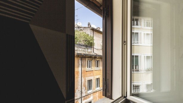 A view through a window of a building with a balcony and a door to the right.