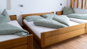 A room with two wooden beds, a ceiling fan, and a dreamcatcher on the wall. - Ideal for mountain lovers, couples and small families  (6653 Bach)