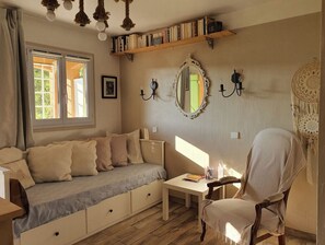 Relax in a comfortable seating area with a sofa and chair, a small table, and a bookshelf.