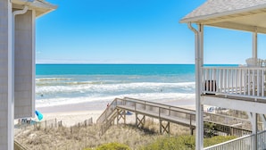 A beach view with a wooden structure and a clear sky.