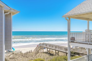 A beach view with a wooden structure and a clear sky.