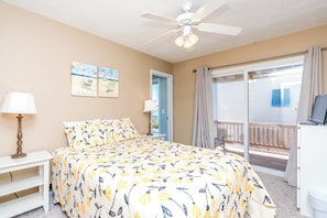 A bedroom with a bed, a desk with a computer, a ceiling fan, and a view of the outside. - Over The Moon - 4 BR home, Oceanfront B-Lot with Amazing Views! Dog Friendly! (Surf City)
