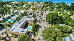 Eine Vogelperspektive eines Küstenresorts mit einem zentralen Gebäude, das einen Swimmingpool umfasst, umgeben von üppiger Vegetation und freiem Blick auf den Ozean.