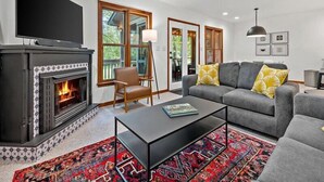 A living room with a fireplace, a sofa, a coffee table, and a television. - Blue Ridge View | Pet Friendly, Deck, Grill + EV Charger (Marion)