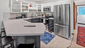 A modern kitchen with a central island, stainless steel appliances, and white cabinetry. - Blue Ridge View | Pet Friendly, Deck, Grill + EV Charger (Marion)