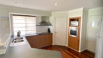 Mikrobølgeovn, ovn, oppvaskmaskin og spisebord