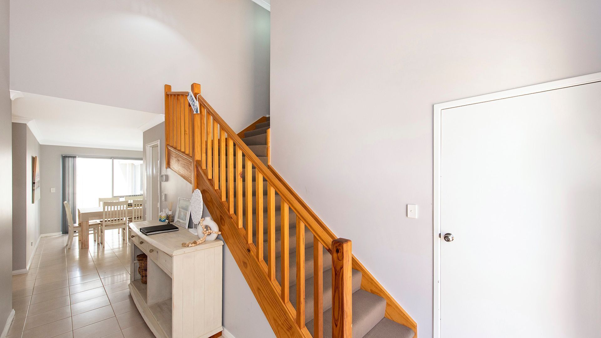 Eine Treppe mit Holzgeländern, die zu einer Zwischenebene führt.