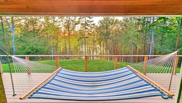 A hammock on a wooden deck with a view of a forest. - Coastal Waterfront Retreat with Sauna, Kayaks & Fire Pit, Freeport, Near LL Bean (Freeport)