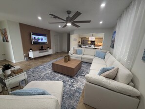 Een moderne woonkamer met een bank, salontafel en televisie.
