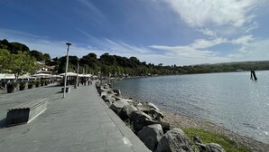 Een promenade aan het water met een stenen voetpad, zitplaatsen en uitzicht op het water.