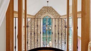 Un arco de piedra con una puerta de cristal y una araña.