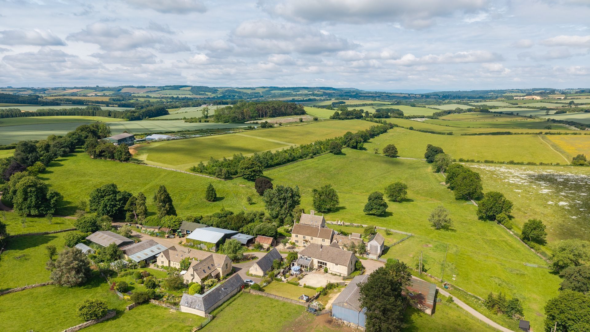 An aerial view of a rural village with houses, fields, and a river.