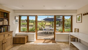 Una habitación amplia con un gran ventanal corredero que da a un patio exterior.