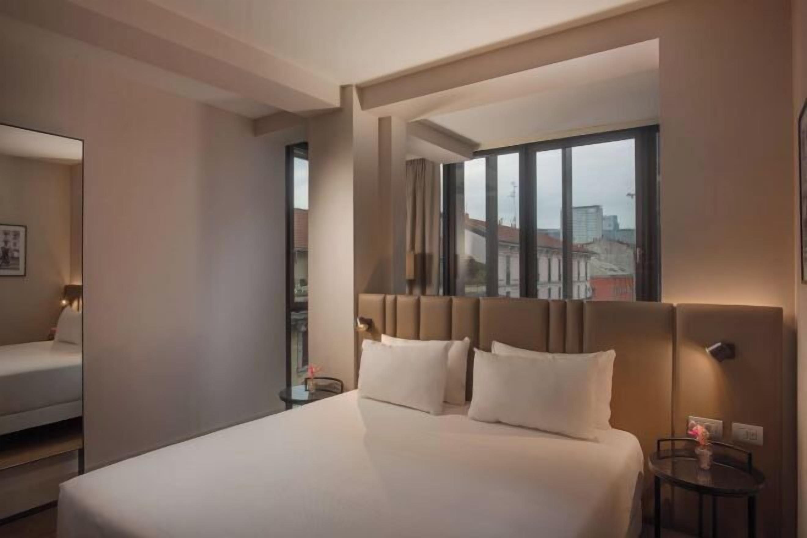 Een minibar, een bureau, een laptopwerkplek, beddengoed