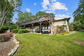 Une maison à deux étages dotée d’un balcon, de fondations en pierre et d’une pelouse bien entretenue.