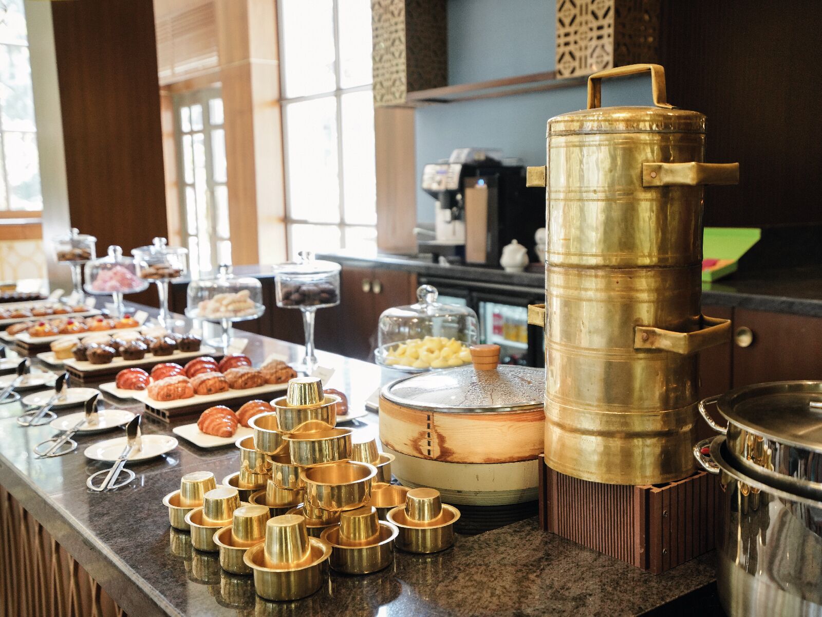 A buffet setup with various food items and serving utensils.