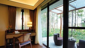A room with a desk, chair, and large windows overlooking a garden. - Rosetta-Sakleshpur (Alur)