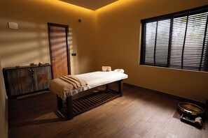 A room with a wooden bed, a small cabinet, a window with blinds, and a wooden floor. - Rosetta-Sakleshpur (Alur)