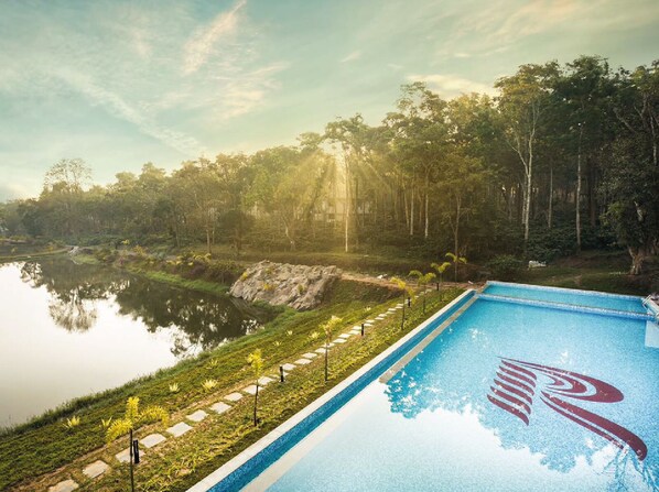 A swimming pool with a clear view of a lake and forested area in the background. - Rosetta-Sakleshpur (Alur)