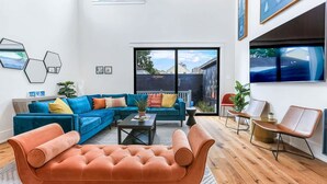 En moderne stue med en hjørnesofa, en puf med knapper og et sofabord.