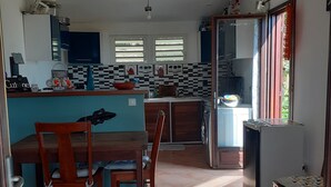 Eine Küche mit Essbereich, mit Fliesenboden, Holzmöbeln und modernem Design.