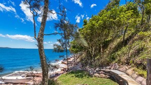 Eine Küstenlandschaft mit freiem Blick auf das Meer, einem Steinweg und einem Kajak.