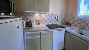 Cocina compacta con microondas, tostadora, cafetera y lavavajillas.