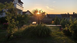Un quartier résidentiel avec des maisons, un jardin et un coucher de soleil.