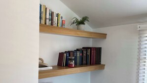 A bookshelf with books and a small potted plant. - Beautiful Cuppin Street Two Bed Apartment (Chester)